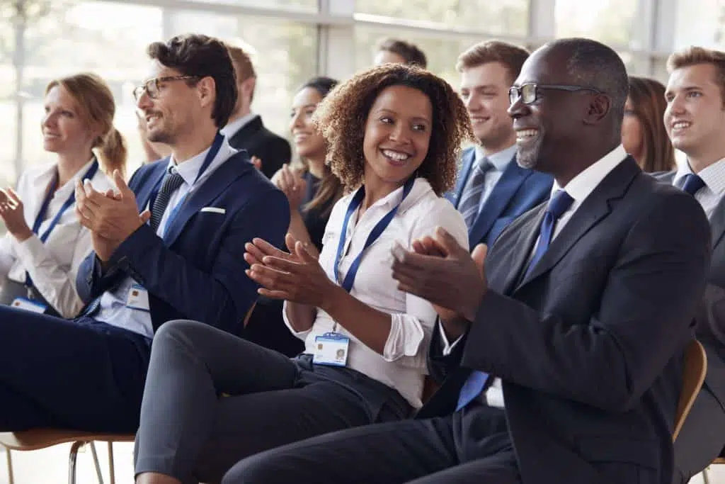 smiling audience applauding at a business seminar P3UTD8Q