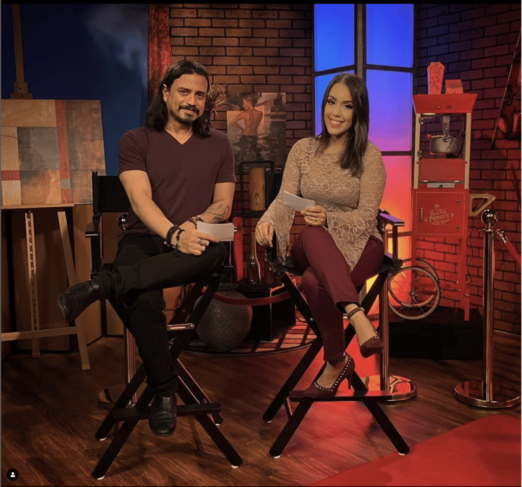 Nando and Christina sitting next to each other in directors chairs. Film and production school.