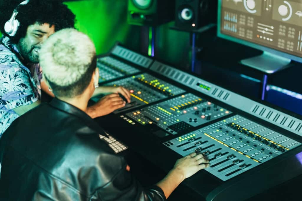 Two students in a recording studio working together to mix and master.