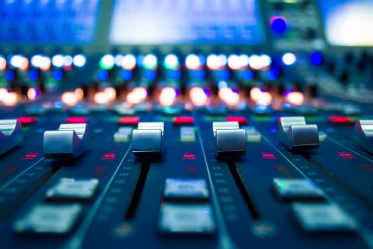 A close-up of a music soundboard in a production studio.