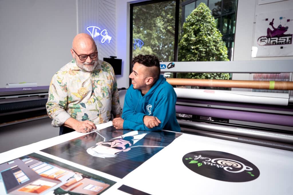 graphic design instructor and student working in print shop